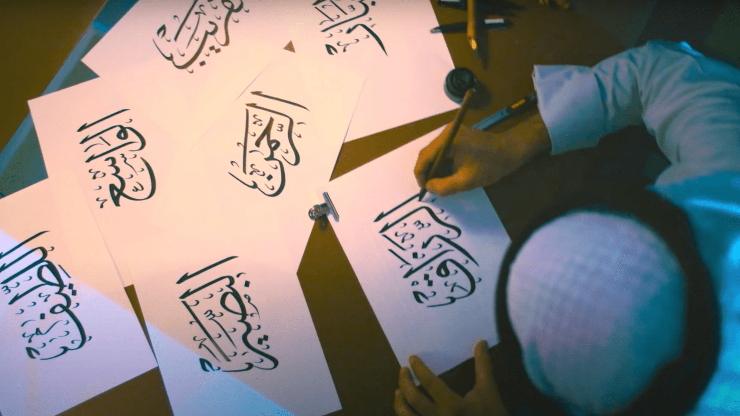 خطّاط يكتب أسماء الله الحسنى في إنتاجات بركة